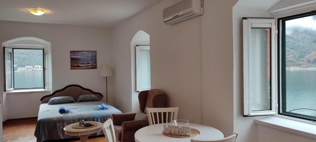 Studio interior at Villa Kamena with bed, dining table and sea view windows